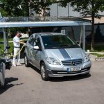 Ein ZSW-Mitarbeiter lädt ein Elektro-Auto am Solar-Carport auf.