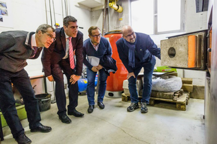 Vertreter der Stadtwerke Rüsselsheim und der Stadtwerke Dreieich werfen gemeinsam einen Blick in die Brennkammer der Rüsselsheimer Holzhackschnitzelanlage.