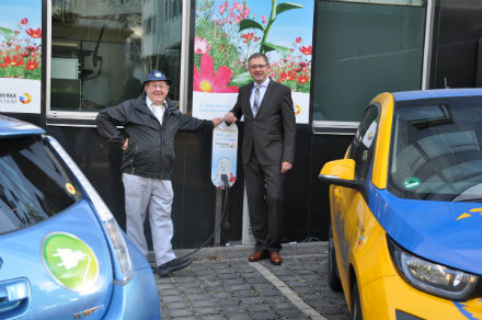 Stadtwerke-Geschäftsführer Dietmar Spohn (rechts) und der Bochumer Elektromobilist Peter Obermann nehmen die Typ 2-Ladesäule am Verwaltungsgebäude der Stadtwerke Bochum in Betrieb.