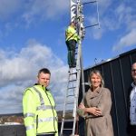 Christopher König bringt das LoRaWAN-Gateway und die Antenne auf dem Ibbenbürener Rathaus an.