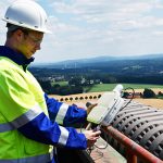 SWTE Netz-Mitarbeiter Felix Schwerter nimmt eines der Gateways für das neue LoRaWAN-Netz auf dem Dach des Kesselhauses des Kraftwerks Ibbenbüren in Augenschein.