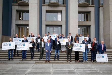 Vertreter der ausgezeichneten Kommunen halten ihre Ortsschilder in der Hand.