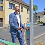 Stadtwerke-Geschäftsführer Frank Thiel testet den Ladepunkt am Laternenmast an der Ümminger Straße in Bochum.