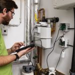 Ein Mitarbeiter der Smart City Solutions GmbH installiert die Sensoren an Gas- und Wasserzählern in einer Hagener Kita.