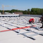 Mitglieder von Olegeno beim Installieren der PV-Anlage auf dem Dach der Quartiersgarage in Helleheide.