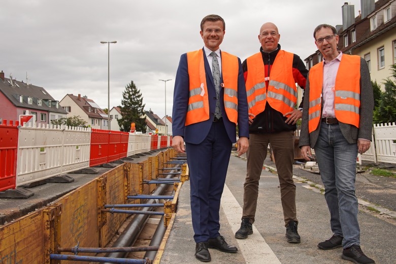 Oberbürgermeister Marcus König, N-ERGIE-Vorstandssprecher Maik Render und Planungs- und Baureferent Daniel F. Ulrich vor der Fernwärmebaustelle.