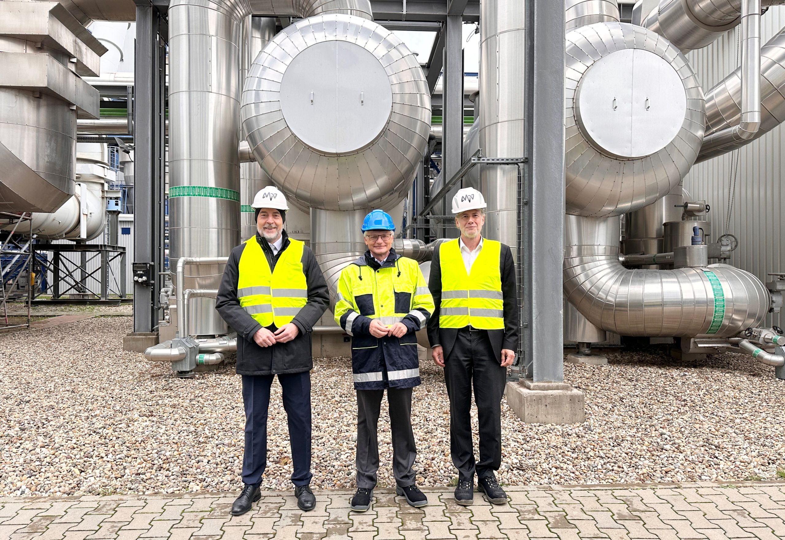 Das Bild zeigt Dr. Hansjörg Roll, Technikvorstand von MVV; Dr. Georg Müller, Vorstandsvorsitzender von MVV; Uwe Zickert, Geschäftsführer MVV Umwelt, vor dem Biomassekraftwerk.