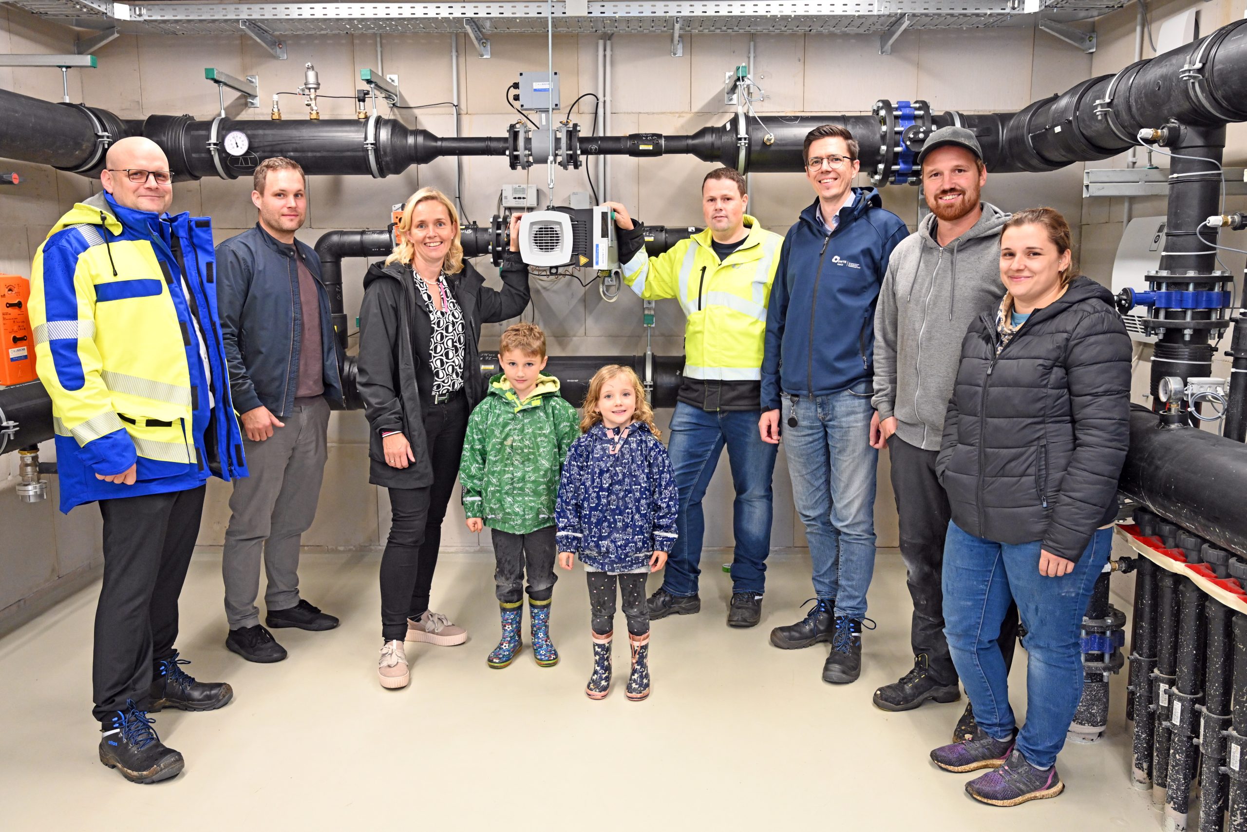 Das Bild zeigt mehrere Persinen in der Technikzentrale des Kalte-Nahwärme-Netzes in Mettingen.