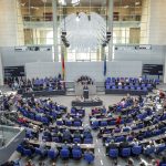 Das Bild zeigt einen Blick in den Plenarsaal des Deutschen Bundestags. Zusehen sind die Reihen der Abgeordneten und im Hintergrund der Bundesadler.